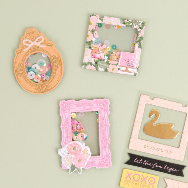 hand-made paper-craft shaker embellishment by Alice Wilks using Primavera by Rosie's Studio. Showcasing chipboard embellishments and frames, puffy stickers and sequins with 12 x 12 papers
